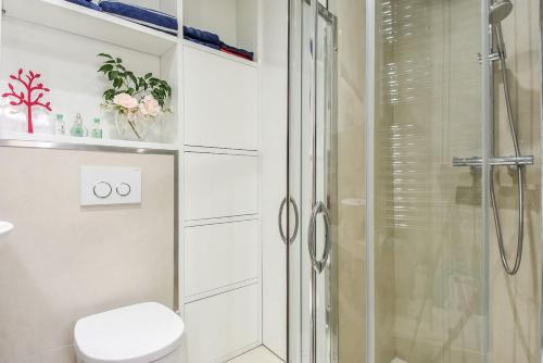 y baño blanco con ducha y aseo. en Charming 1BR Apartment In Heart Of Monaco, en Montecarlo