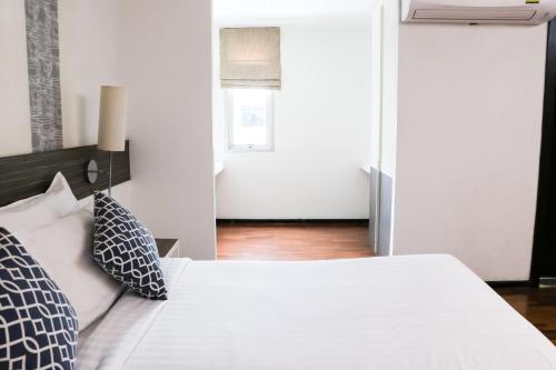 a bedroom with a white bed with black and white pillows at The Mini R Ratchada in Bangkok