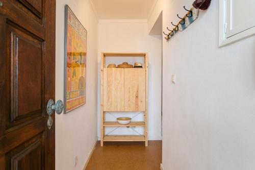 un pasillo con una pared blanca y una puerta de madera en Maresia - Beachfront Peniche Apartment, en Peniche