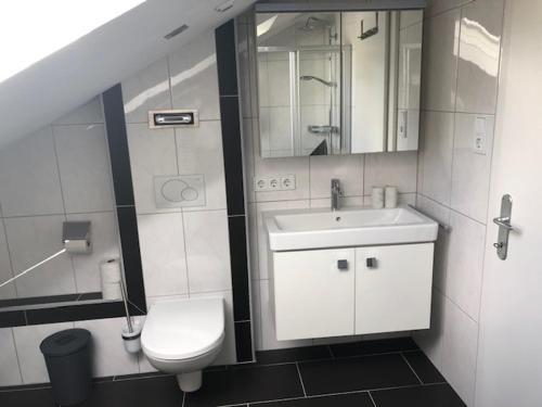 ein Badezimmer mit einem Waschbecken, einem WC und einem Spiegel in der Unterkunft Kienburg in Matrei in Osttirol