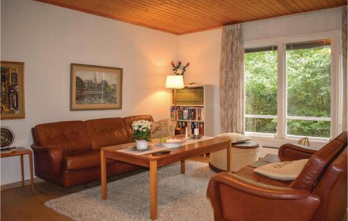 a living room with a couch and a table at Lovely Home In Hjärnarp With Sauna in Hjärnarp