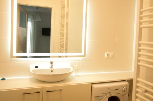 a bathroom with a sink and a mirror at Apartament Verde in Łódź