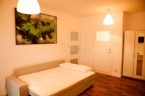 a bedroom with a bed and a painting on the wall at Apartament Verde in Łódź