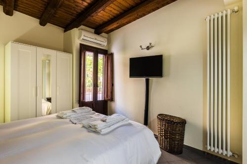 um quarto com uma cama e uma televisão na parede em La casetta al Massimo by DomuSicily em Palermo