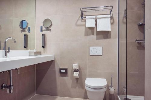 a bathroom with a toilet and a sink and a shower at PLAZA Premium Den Haag City Center in The Hague