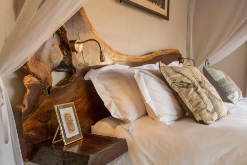 a bedroom with a bed with a wooden head board at Ukuthula Bush Lodge in Hoedspruit