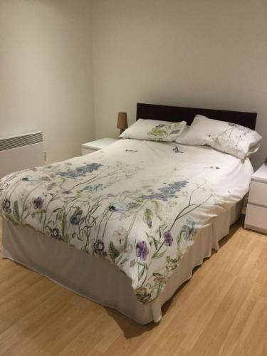 a bedroom with a bed with a floral bedspread at Riverheights very near SSE Hydro in Glasgow