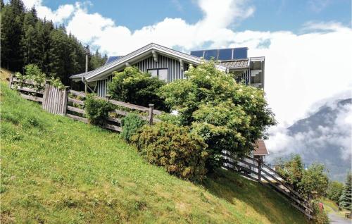 una casa en una colina con una valla de madera en Ferienwohnung Hohe Tauern, en Mörtschach
