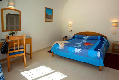 a bedroom with a bed and a table and a desk at Samira Club Family and couples only in Hammamet