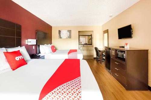 a hotel room with two beds and a tv at OYO Hotel Tyler Northwest Mineola Hwy in Tyler