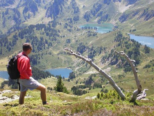 a man with a backpack standing on top of a mountain at Le Pas de L'Ours in Aston