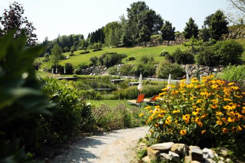 a path through a garden with yellow flowers at RelaxResort Kothmühle in Neuhofen an der Ybbs