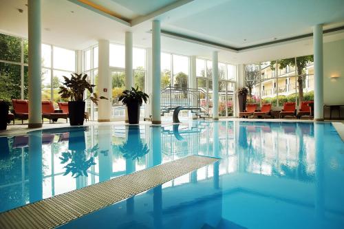 a swimming pool with blue water in a building at RelaxResort Kothmühle in Neuhofen an der Ybbs