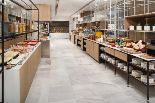 una gran cocina con muchos mostradores y estanterías con comida en Melia Sevilla, en Sevilla