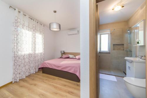 - une chambre avec un lit, une douche et un lavabo dans l'établissement Apartments Zvonik, à Brist