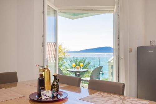 a dining room table with a view of the ocean at Apartments Zvonik in Brist