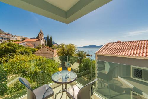 a balcony with a glass table with two glasses on it at Apartments Zvonik in Brist
