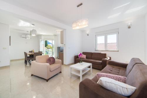 a living room with a couch and chairs and a table at Apartments Zvonik in Brist