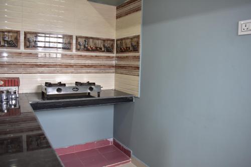a kitchen with a stove on a counter top at Malakar Home stay in Port Blair