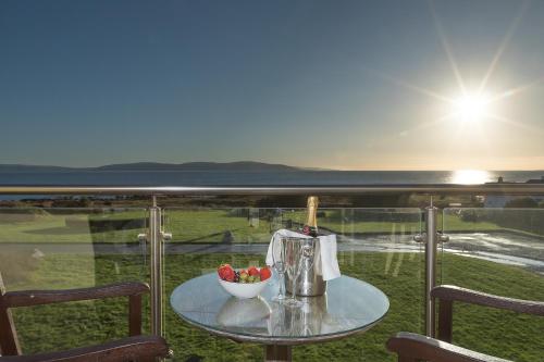 Connemara Coast Hotel في Furbo: طاولة زجاجية مع وعاء من الفواكه على شرفة