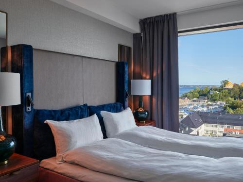 
a hotel room with a large bed and a large window at Radisson Blu Caledonien Hotel, Kristiansand in Kristiansand
