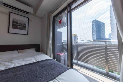 a bedroom with a bed and a large window at SHINJUKU Residence BLDG in Tokyo