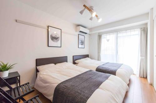 a bedroom with two beds and a window at SHINJUKU Residence BLDG in Tokyo