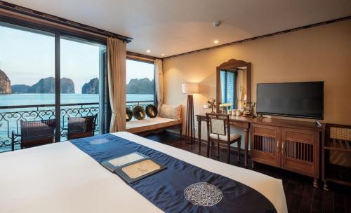 a bedroom with a bed and a flat screen tv at Indochine Cruise Lan Ha Bay Powered by ASTON in Ha Long