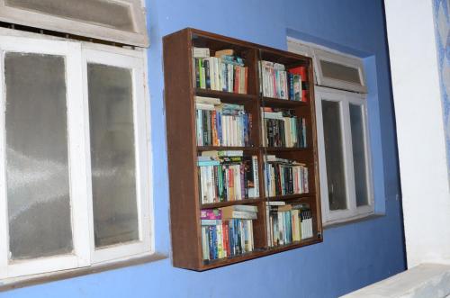 a book shelf filled with books in a room with a window at Libton Manor in Candolim