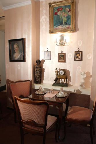 a room with a table with chairs and a painting on the wall at Hotel Café Adler 24h self check in in Triberg