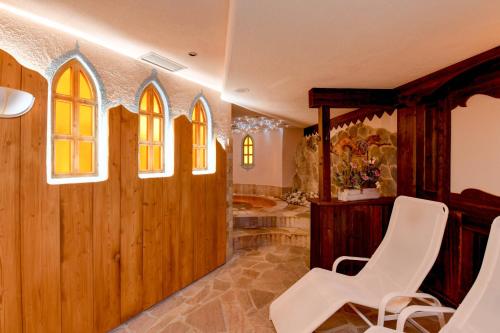 a room with wooden walls and a white chair at Hotel Gianna in Madonna di Campiglio