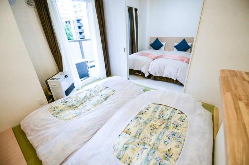 a small room with two beds and a window at momo premium 603 in Sapporo