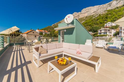 a patio with a couch and a table with fruit on it at Apartments Zvonik in Brist