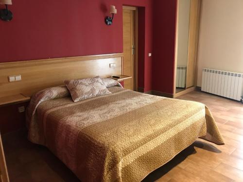 1 dormitorio con cama y pared roja en Hotel Rural El Alberche, en Burgohondo