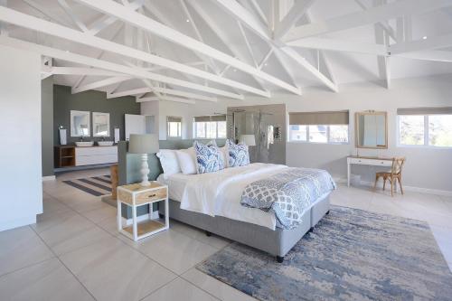 a large bedroom with a bed and a table at 269 on Main Holiday Home in Hermanus