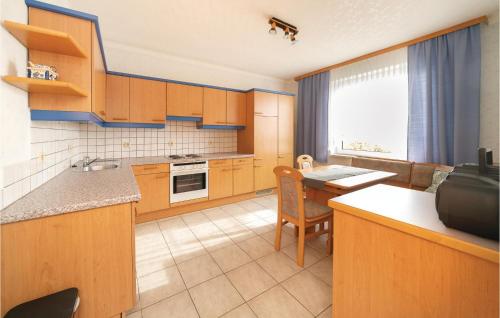 a kitchen with wooden cabinets and a table and a counter at Ferienhaus Mit Panoramablick in Eisenberg an der Pinka