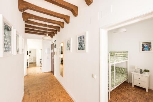 einen Flur eines Hauses mit weißen Wänden und Holzdecken in der Unterkunft Apartamentos Coloreros, SOL, Madrid Centro in Madrid