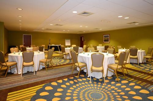 a banquet room with white tables and chairs at Holiday Inn Express Boston Brockton by IHG in Brockton