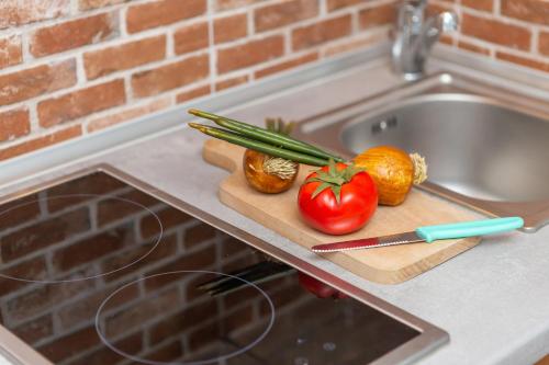 a cutting board with vegetables on top of a sink at Apartamenty Pod Wieżyczkami by Renters in Międzyzdroje