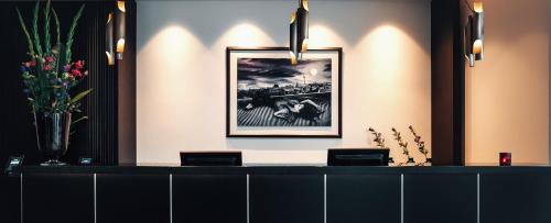 a reception desk in a room with a picture on the wall at Holiday Inn Berlin City Center East Prenzlauer Berg by IHG in Berlin