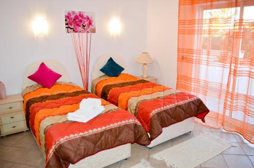 2 Betten nebeneinander in einem Zimmer in der Unterkunft Algarpraia in Carvoeiro
