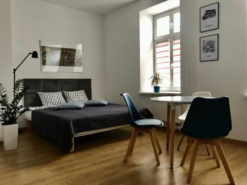 a bedroom with a bed and a table and chairs at Poznan Rents - Apartamenty Mostowa Old Town Parking Free in Poznań