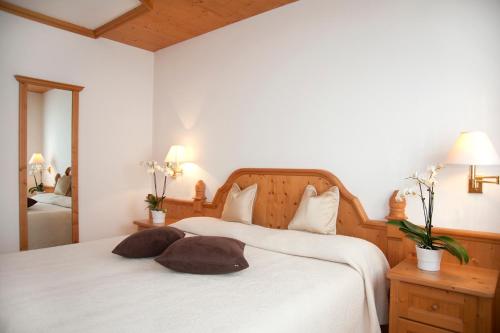 a bedroom with a white bed with two pillows on it at Residence Peniè in San Vito di Cadore