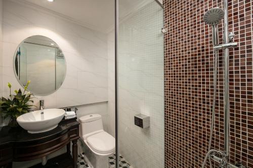 a bathroom with a toilet and a sink and a mirror at Maya Boutique Hotel & Spa in Hanoi