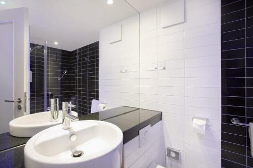 a white bathroom with a sink and a mirror at Holiday Inn Express Neunkirchen by IHG in Neunkirchen