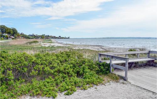 a bench sitting on a boardwalk next to the beach at Gorgeous Home In Egå With Wifi in Egå