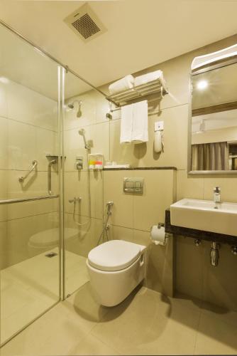a bathroom with a toilet and a sink and a shower at Floressa Randa Business Hotel in Chennai