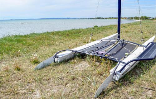a boat sitting on the grass next to the water at Gorgeous Home In Egå With Wifi in Egå
