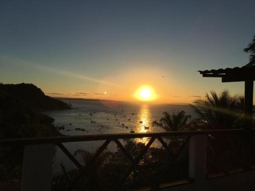 a sunset over the ocean with boats in the water at Casas Coloniais in Morro de São Paulo