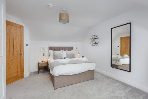 a bedroom with a large bed and a mirror at Dollar Apartments-41 Bridge Street in Dollar